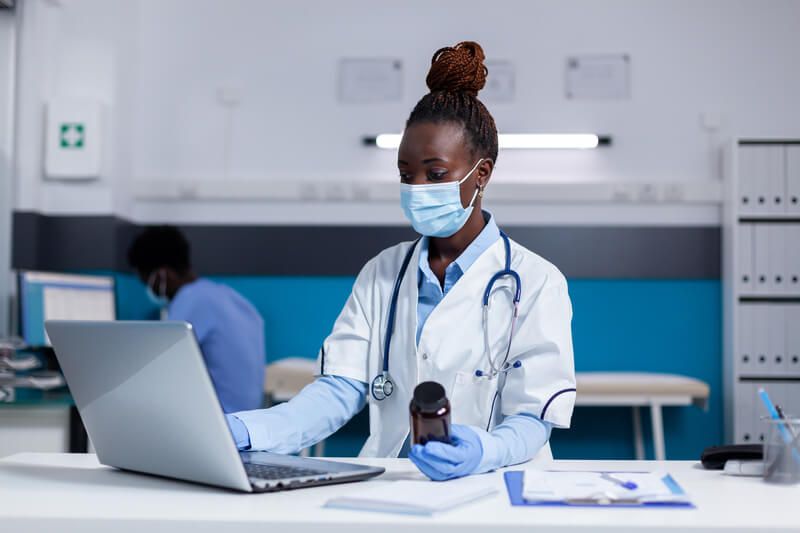 Médica realizando consulta online com paciente.